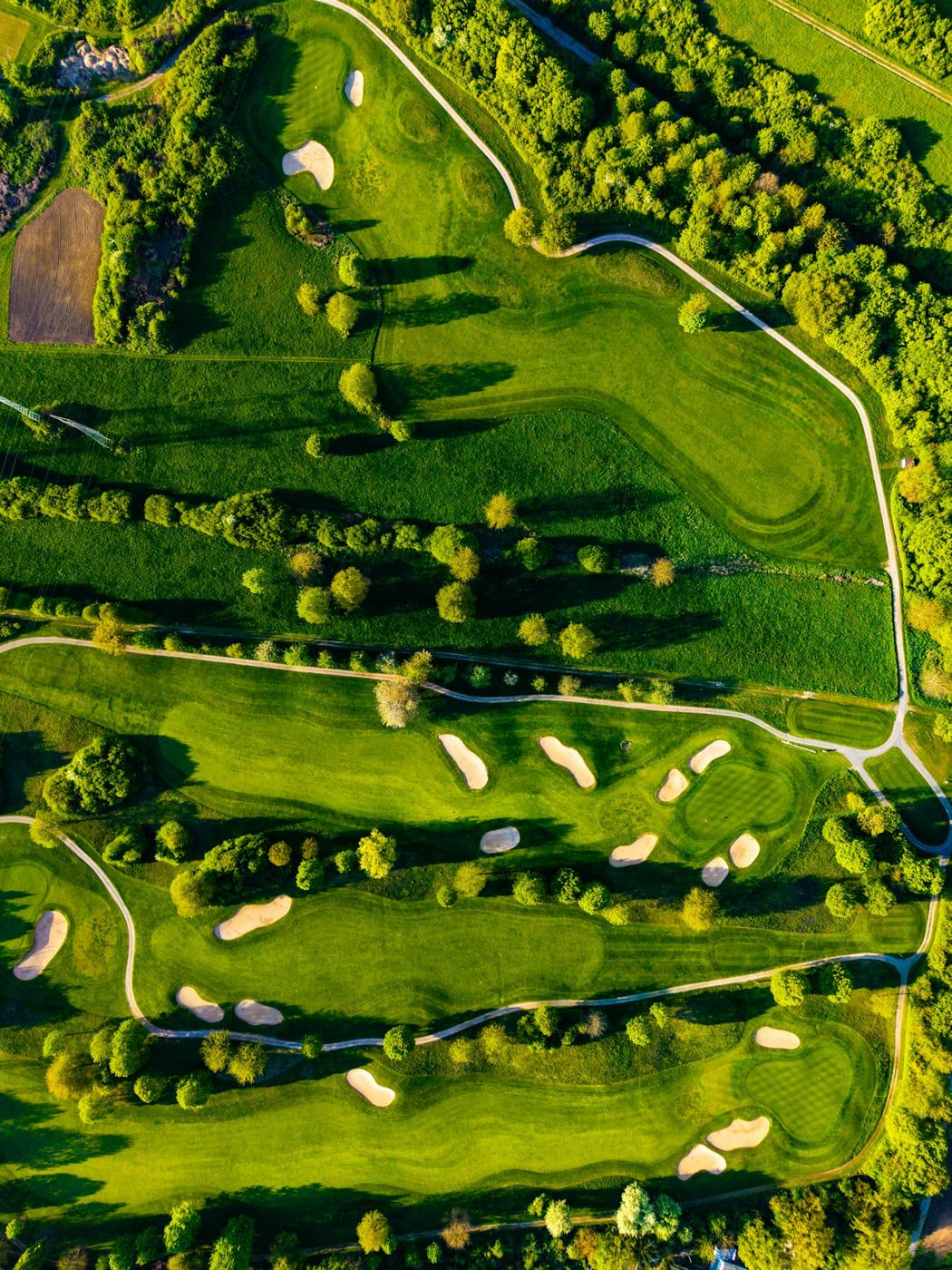 A green golf course with fairways and bunkers